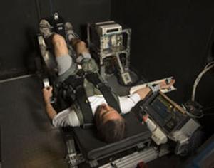 An astronaut is strapped into a G-Force simulator.