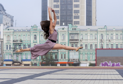 Image of dancer leaping with city skyline in the background