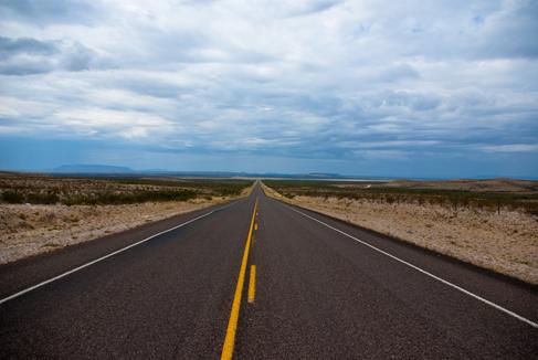 A picture of an empty highway in the desert.