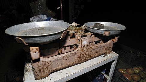 A double-pan mechanical balance is shown. A metal mass is sitting in the left pan.