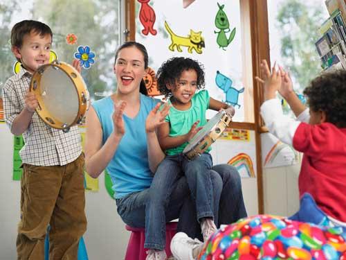 Image of children with percussion instruments in a classroom with their teacher