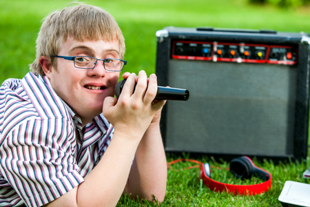 Image of a special education student with microphone and speaker
