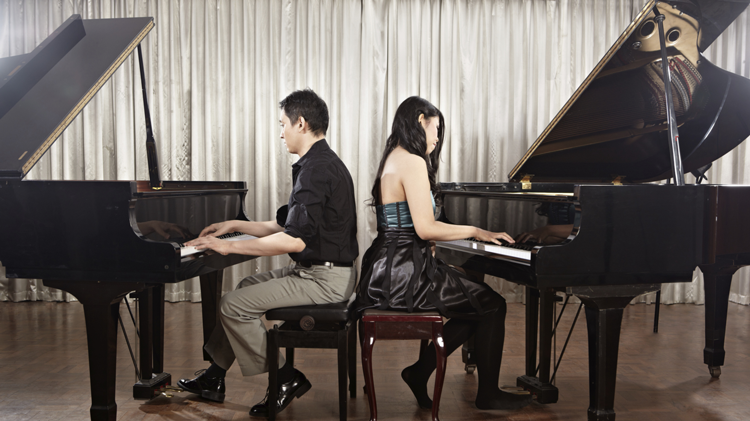 Image of two students playing pianos