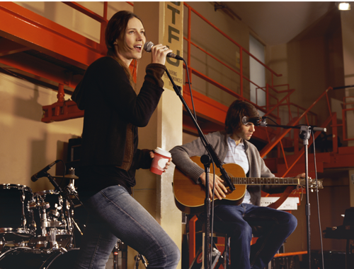 A woman singing and man playing guitar in a coffee shop