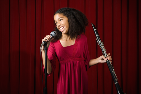 Image of girl on stage with clarinet and microphone