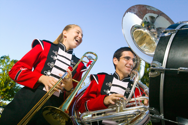 Image of students in a circle having a discussion and using tablets and laptops