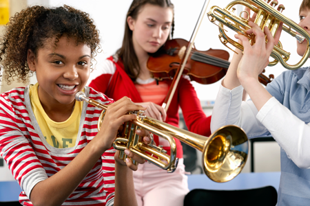 Image of students sitting in front of teacher with guitar