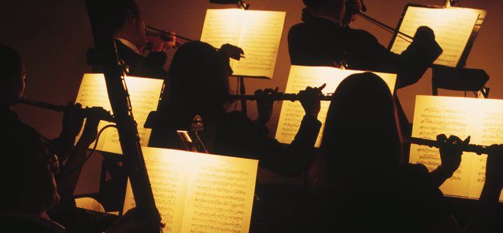 Image of classical musicians with illuminated sheet music