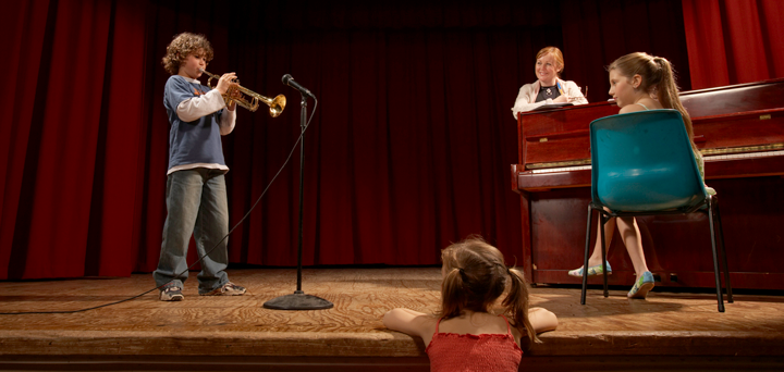 Image of classical musicians led by a conductor in rehearsal