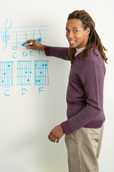 Image of music teacher writing chords on white board