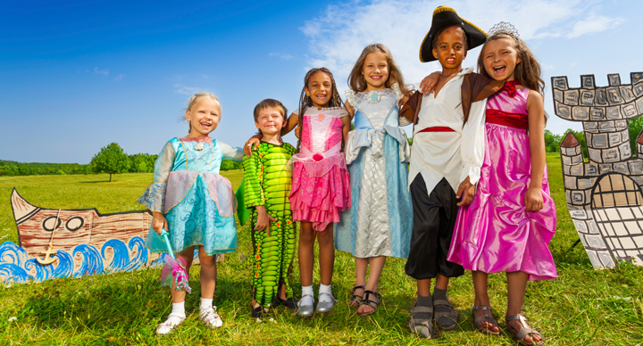 Group of young children in costumes in front of a set