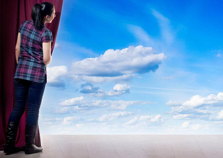 Young child on stage reading lines to instructor