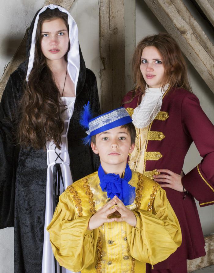 Three children dressed in period costumes