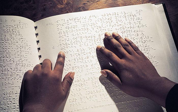 student mime and student reading braille